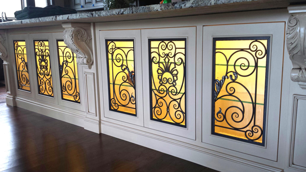 European scroll pattern behind the glass of bar cabinets