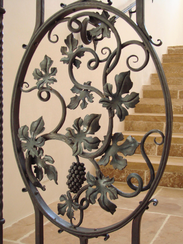 Hand forged grape accent in a hand rail near the wine cellar